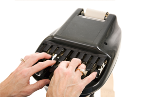 Hands typing on a black stenotype machine