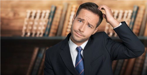 Confused businessman in suit scratching head