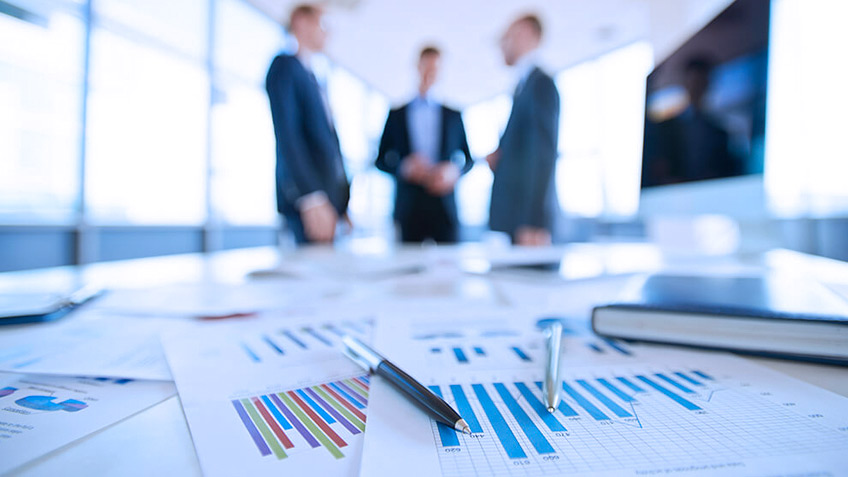Financial charts and pens on meeting table