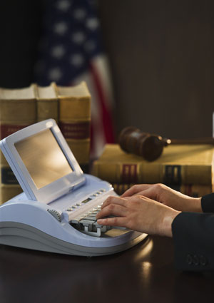 Court reporter typing on stenotype machine
