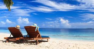 Two lounge chairs on tropical sandy beach